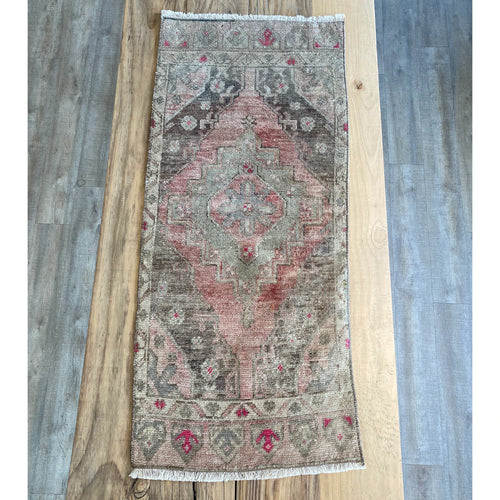 Turkish rug in Pale green with rose and pale pink, brown and pops of hot pink.
