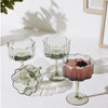 Set of 4 stemmed champagne coupe glasses with cocktails.