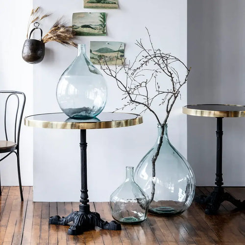 Antique glass bottles styled with long, budding branches in them. 
