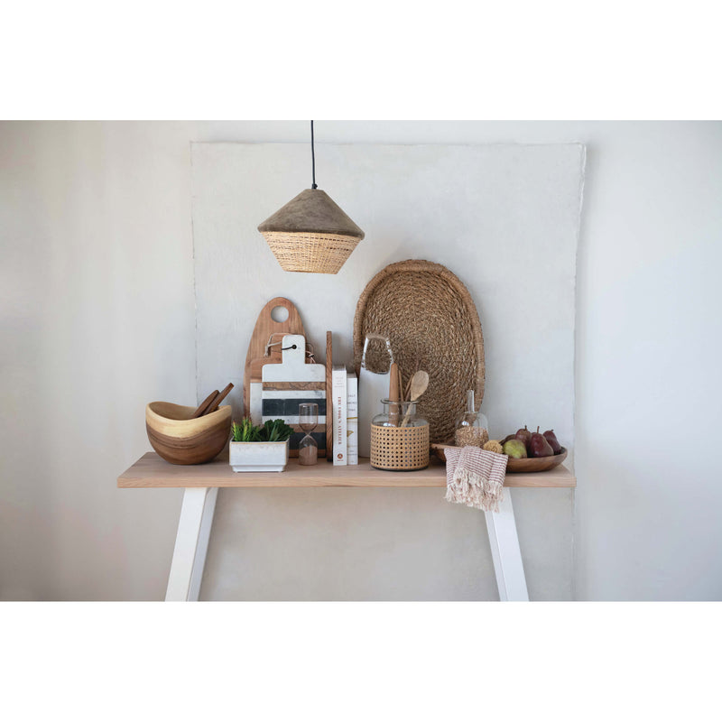 Woven tray with handles styled in a scandinavian style kitchen with wooden bowls and cooking books.