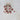 Decorative string of red and white mushrooms on a textured white surface.