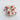 Decorative string with red and white mushroom-shaped ornaments on a textured white surface.