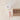 Glass of hot chocolate with whipped cream and candy cane stir sticks on a beige surface.