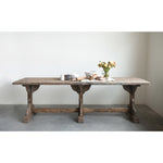 Long wood dining table with flowers in a vase on top.