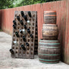 Waxed barrels stacked next to a wine holder.